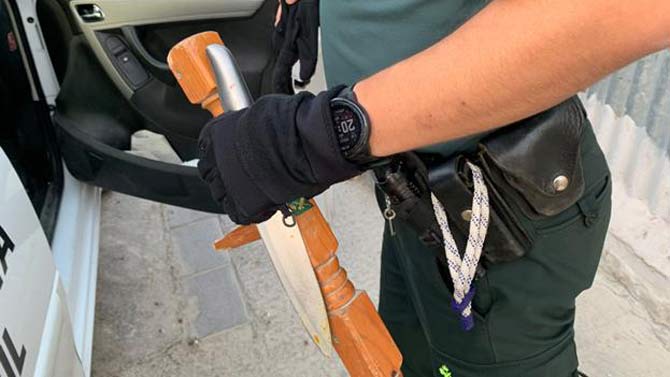 Un agente de la Guardia Civil custodia el cuchillo y el palo intervenidos tras la pelea