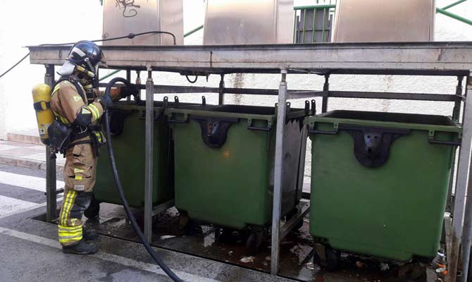 Un bombero realiza labores en los contenedores afectados
