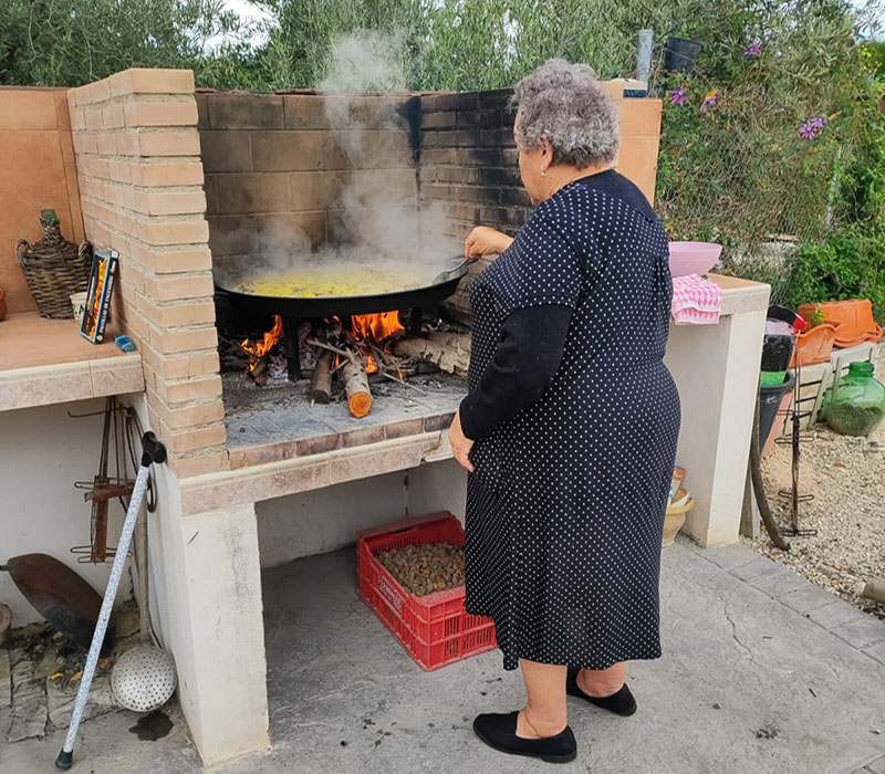 La matrialca preparando el típico arroz y conejo