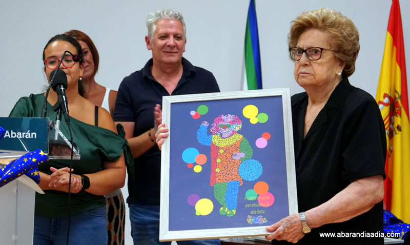 Trini, madre de Isa, junto al cartel y su autor