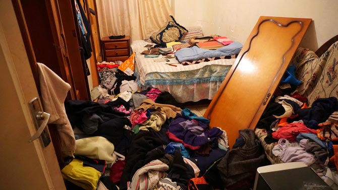 Una de las habitaciones con una de las puertas del armario rota y todo removido