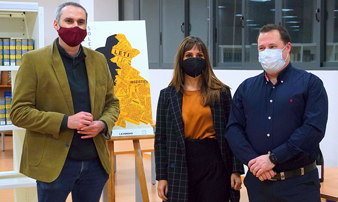 La autora el cartel junto a dos de los premiados